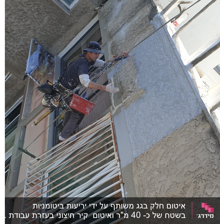 אדם מבצע איטום קיר חיצוני עם מברשת